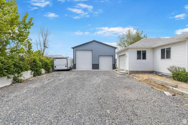 detached garage featuring fence