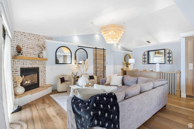 living room with a fireplace, wood finished floors, and lofted ceiling