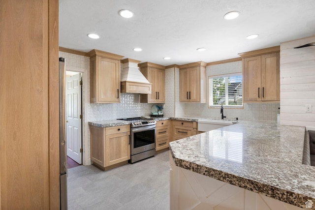 kitchen with light brown cabinetry, tasteful backsplash, a sink, custom exhaust hood, and stainless steel electric stove