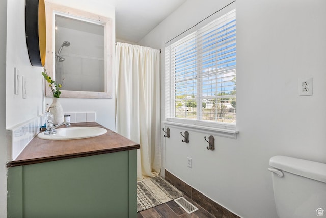 full bathroom featuring vanity, toilet, baseboards, wood finished floors, and visible vents