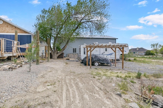rear view of property featuring a pergola and a carport