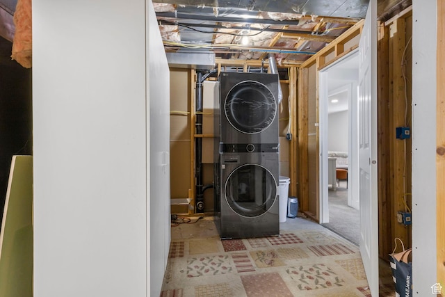 clothes washing area featuring laundry area and stacked washing maching and dryer