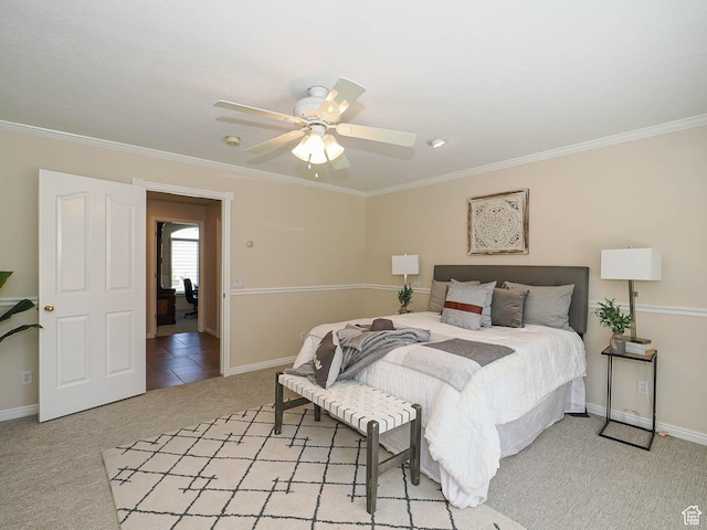 bedroom featuring baseboards, crown molding, light colored carpet, and a ceiling fan