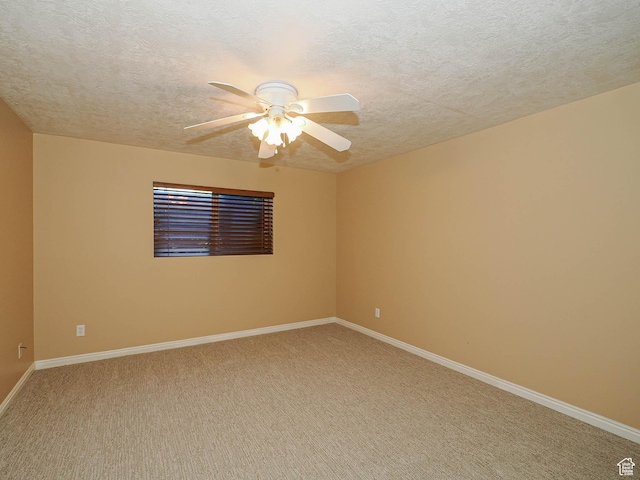 empty room featuring baseboards, light colored carpet, a textured ceiling, and ceiling fan