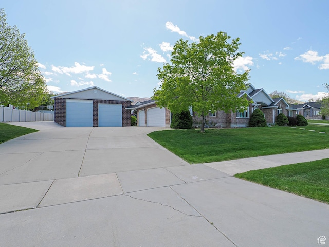 single story home featuring fence, a front lawn, brick siding, and a detached garage