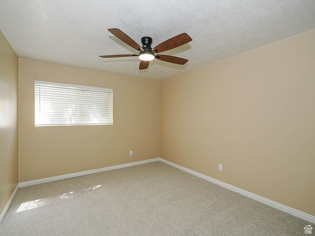 empty room featuring carpet flooring, baseboards, and ceiling fan