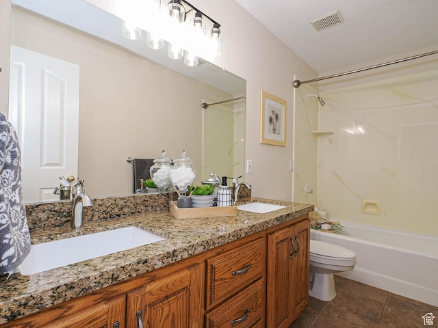 bathroom with visible vents, a sink, double vanity, and toilet