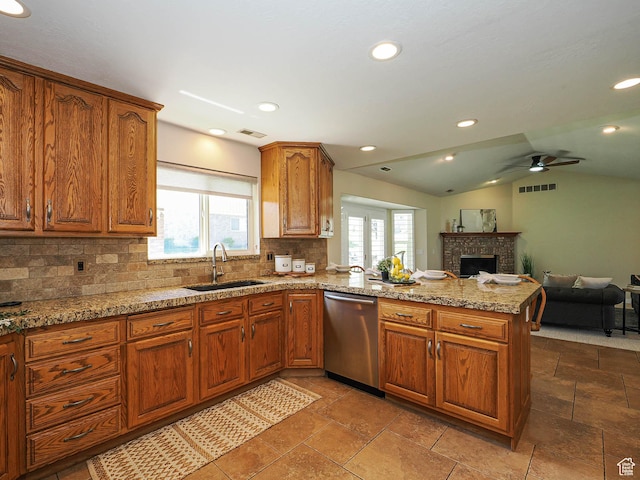 kitchen with backsplash, dishwasher, a ceiling fan, a sink, and a peninsula