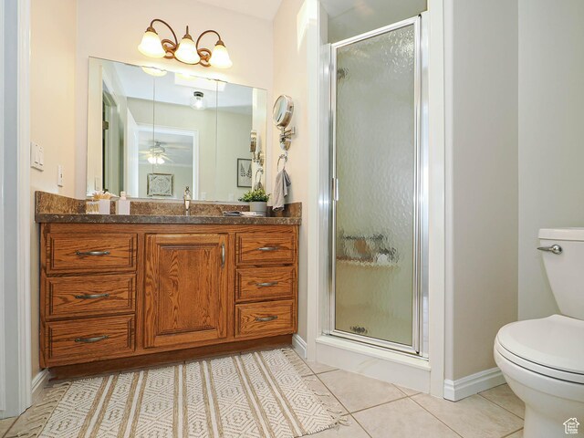 bathroom with tile patterned flooring, a shower stall, toilet, and vanity