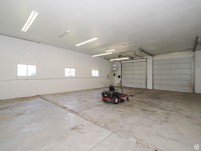 garage featuring concrete block wall and a wall unit AC