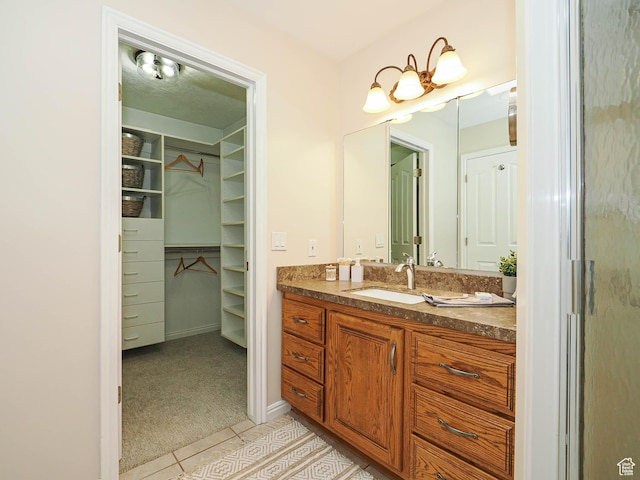 bathroom featuring vanity, tile patterned flooring, and a spacious closet
