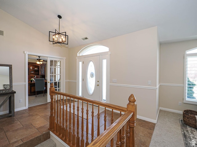 foyer entrance featuring stone tile floors, baseboards, and visible vents