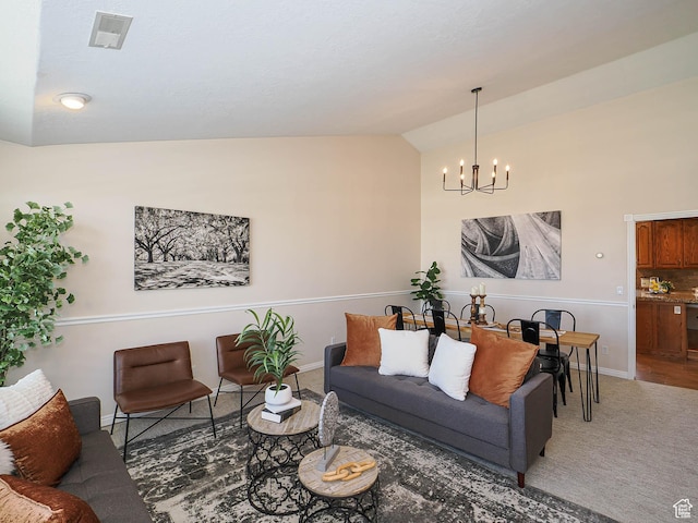 carpeted living area with lofted ceiling, baseboards, visible vents, and an inviting chandelier