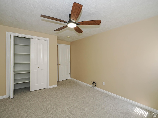 unfurnished bedroom with a textured ceiling, baseboards, and light carpet