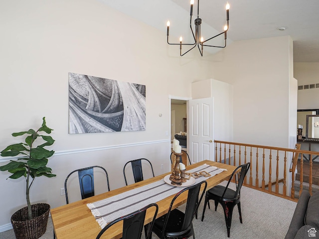 dining space featuring a towering ceiling, visible vents, and an inviting chandelier