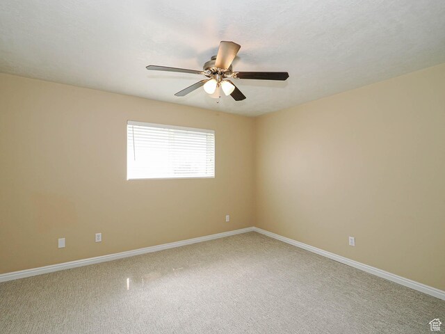 unfurnished room with a ceiling fan, baseboards, and light colored carpet