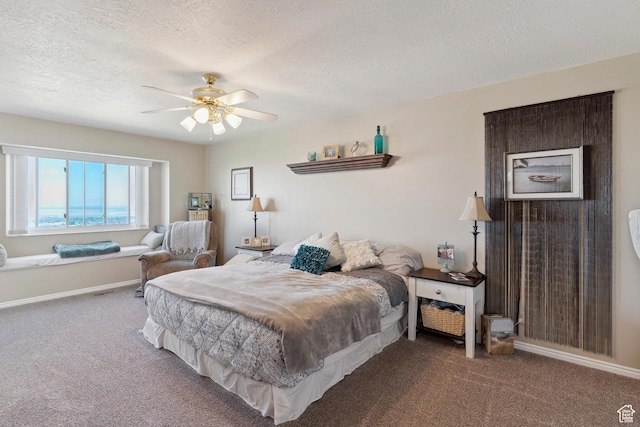 bedroom with carpet, a textured ceiling, baseboards, and a ceiling fan