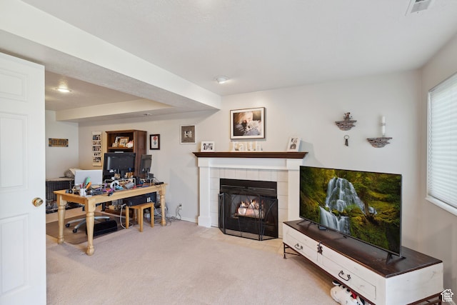 carpeted living area with a fireplace, baseboards, and visible vents