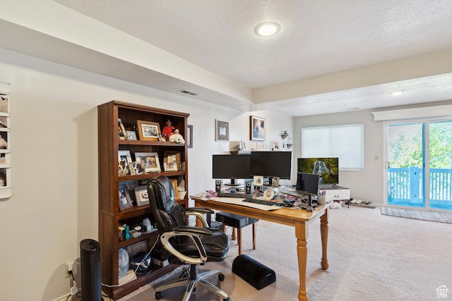 office area featuring a textured ceiling, carpet flooring, and visible vents