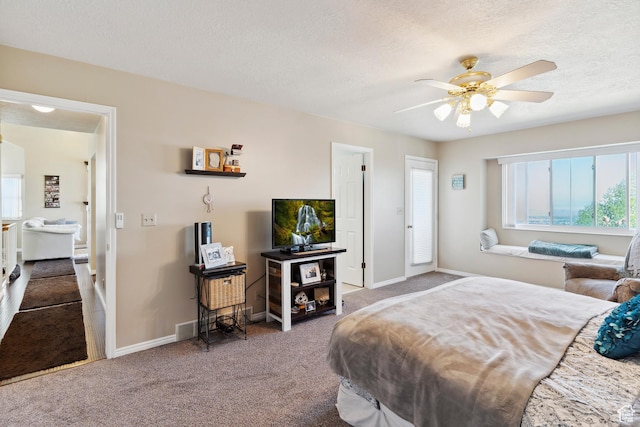 carpeted bedroom featuring a textured ceiling, visible vents, baseboards, and ceiling fan