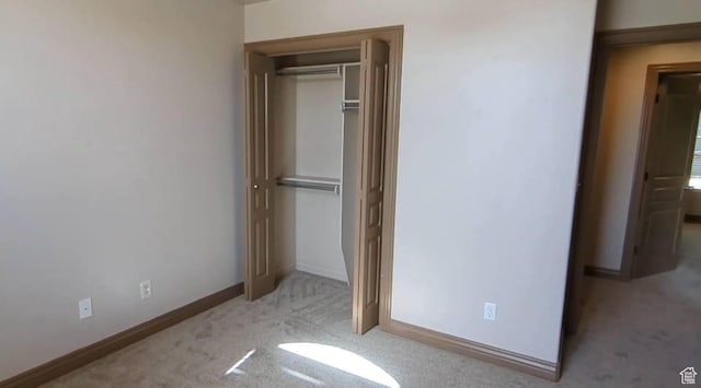 unfurnished bedroom featuring carpet floors, a closet, and baseboards