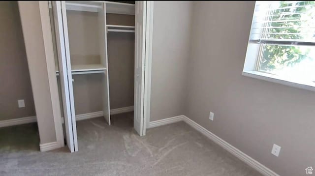 unfurnished bedroom featuring a closet, carpet floors, and baseboards