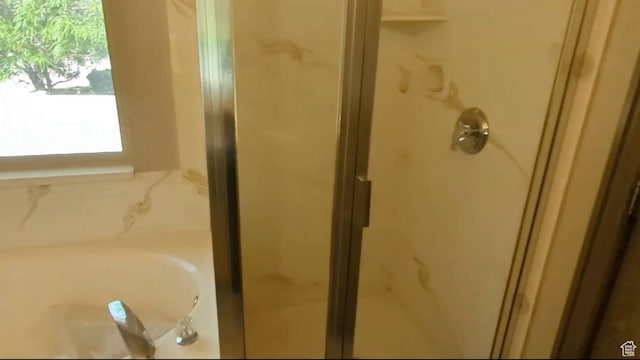 bathroom featuring a stall shower and a bath