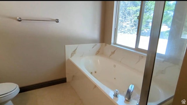 bathroom with a whirlpool tub, toilet, and tile patterned flooring