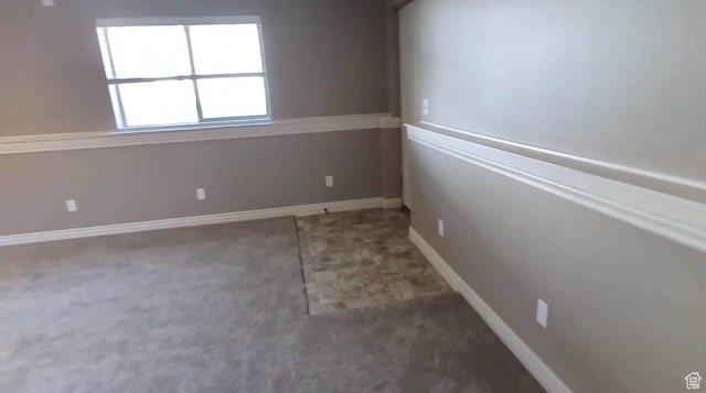 unfurnished room with baseboards
