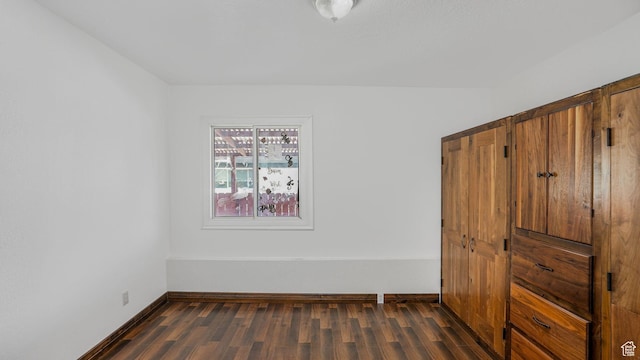 3760 S 3325 W, West Valley City, UT 84119 - unfurnished bedroom with baseboards and dark wood-type flooring