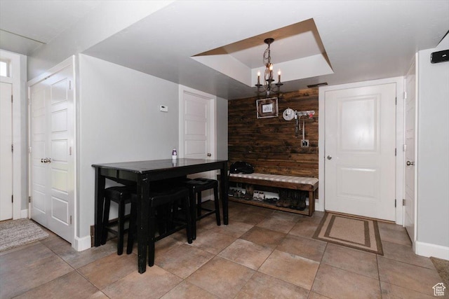 9 W Cedar Ln, Franklin, ID 83237 - dining space featuring a tray ceiling, baseboards, wooden walls, and a chandelier