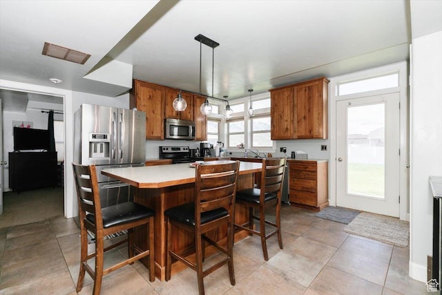 9 W Cedar Ln, Franklin, ID 83237 - kitchen with appliances with stainless steel finishes, brown cabinetry, light countertops, and a kitchen island