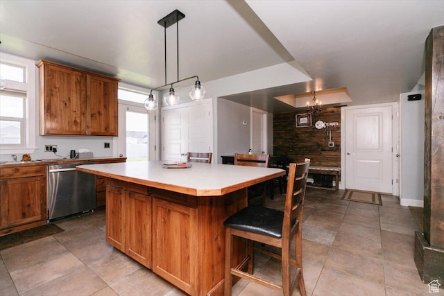 9 W Cedar Ln, Franklin, ID 83237 - kitchen featuring stainless steel dishwasher, brown cabinetry, a center island, and a breakfast bar