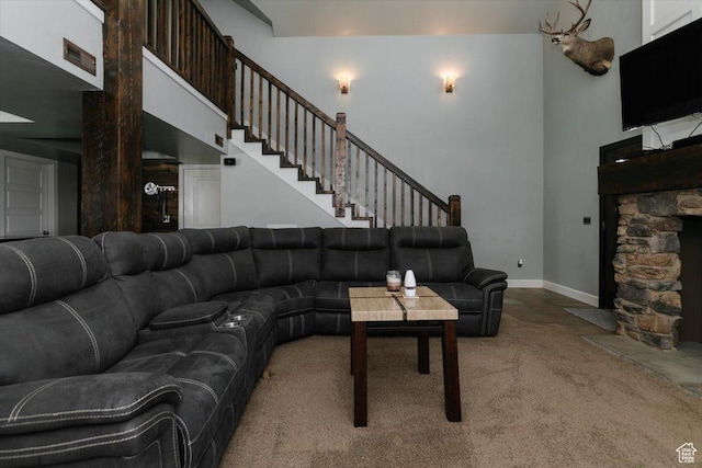 9 W Cedar Ln, Franklin, ID 83237 - living area featuring carpet flooring, a towering ceiling, baseboards, a stone fireplace, and stairway