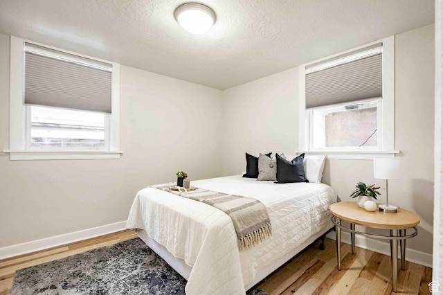 555 E 100 S Unit 105, Salt Lake City, UT 84102 - bedroom with light wood finished floors, baseboards, and multiple windows