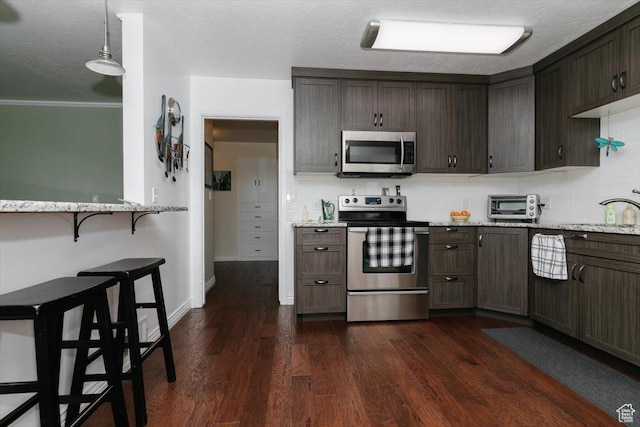 449 S 2nd E, Preston, ID 83263 - kitchen with light stone countertops, stainless steel appliances, dark brown cabinetry, and backsplash
