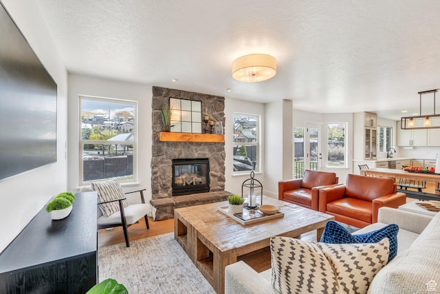 2696 W Red Robin Ct, Lehi, UT 84043 - living room with a textured ceiling, light wood finished floors, and a fireplace