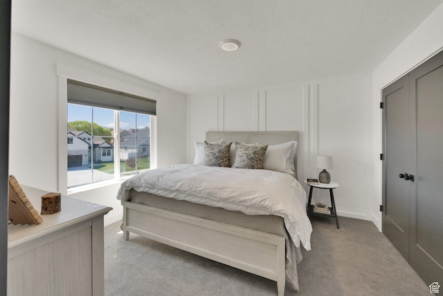bedroom featuring light colored carpet and a decorative wall