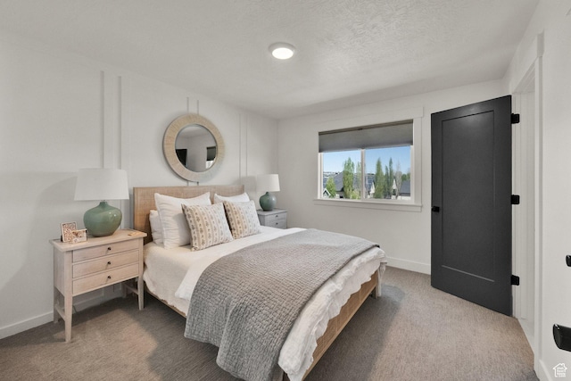 carpeted bedroom featuring baseboards and a textured ceiling