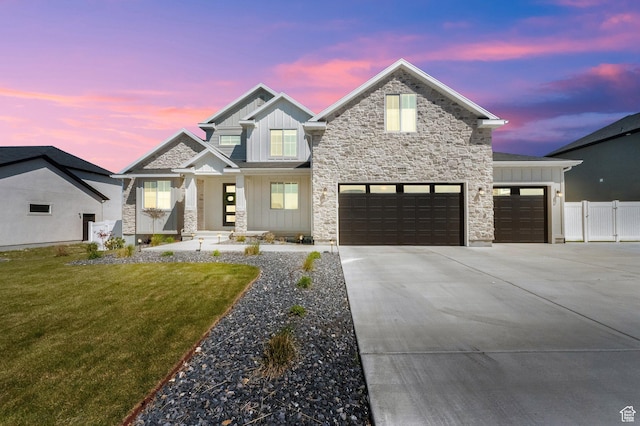 view of front of house featuring driveway, fence, a garage, board and batten siding, and a yard