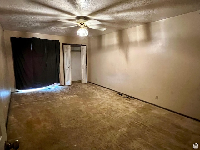 unfurnished bedroom with ceiling fan, baseboards, a textured ceiling, and carpet