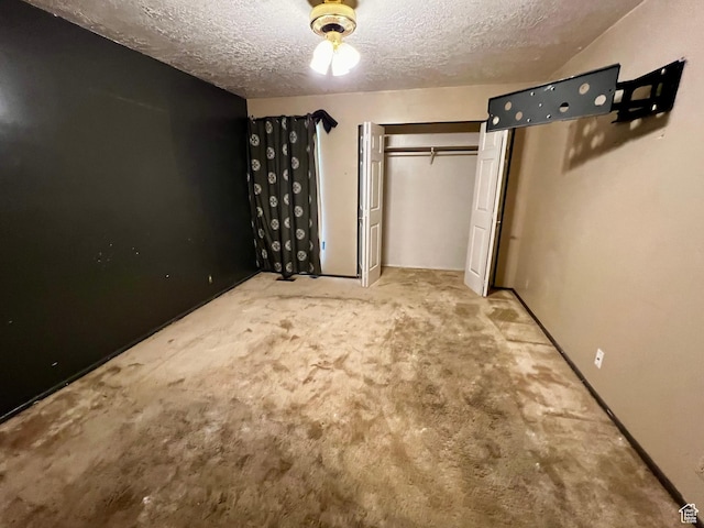 unfurnished bedroom with a closet, a textured ceiling, and carpet flooring