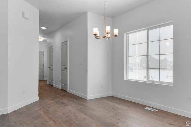 6717 N Tulle Mtn, Eagle Mountain, UT 84005 - empty room with baseboards, a notable chandelier, hardwood / wood-style floors, and visible vents