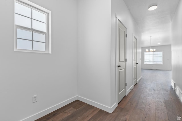6717 N Tulle Mtn, Eagle Mountain, UT 84005 - hall featuring baseboards, dark wood-style floors, and a notable chandelier