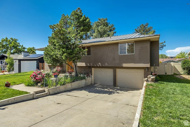 371 E 6770 S, Midvale, UT 84047 - view of front of home with an attached garage, a standing seam roof, concrete driveway, metal roof, and brick siding