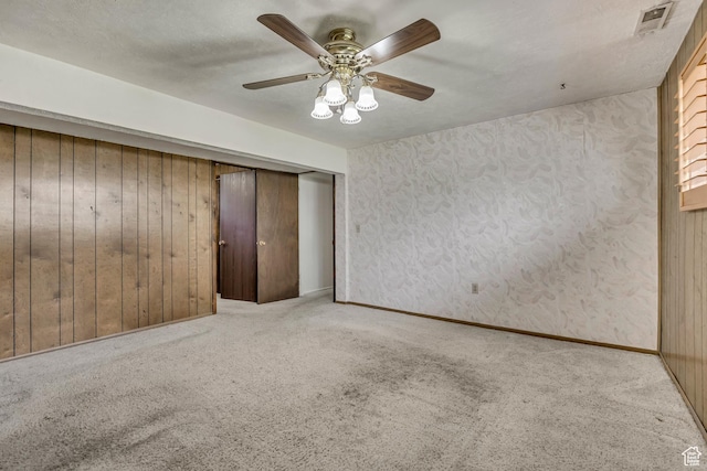 371 E 6770 S, Midvale, UT 84047 - unfurnished bedroom featuring carpet floors, a closet, wooden walls, and ceiling fan