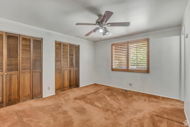 371 E 6770 S, Midvale, UT 84047 - unfurnished bedroom featuring multiple closets, carpet flooring, ornamental molding, baseboards, and a ceiling fan