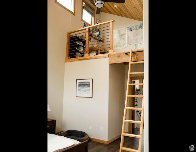 bedroom with vaulted ceiling, wood finished floors, and baseboards