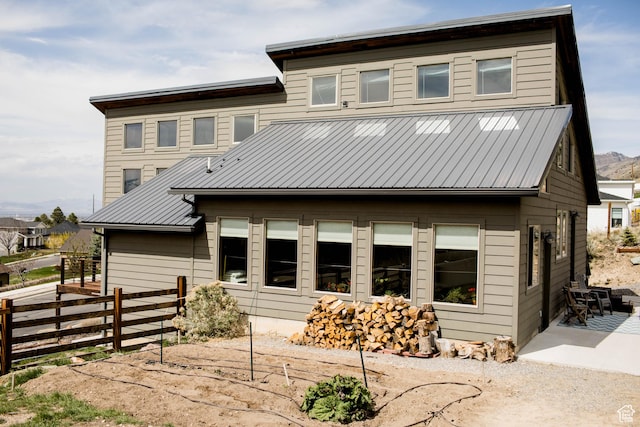 view of front of home featuring fence, a patio area, and metal roof