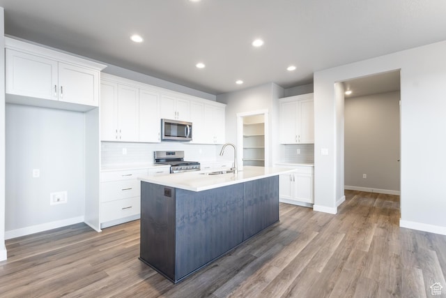 2833 W 3050 N Unit 11, Plain City, UT 84404 - kitchen with stainless steel appliances, a sink, a kitchen island with sink, tasteful backsplash, and white cabinetry